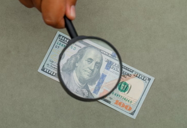 prosperity principle money numbers header image of money and magnifying glass